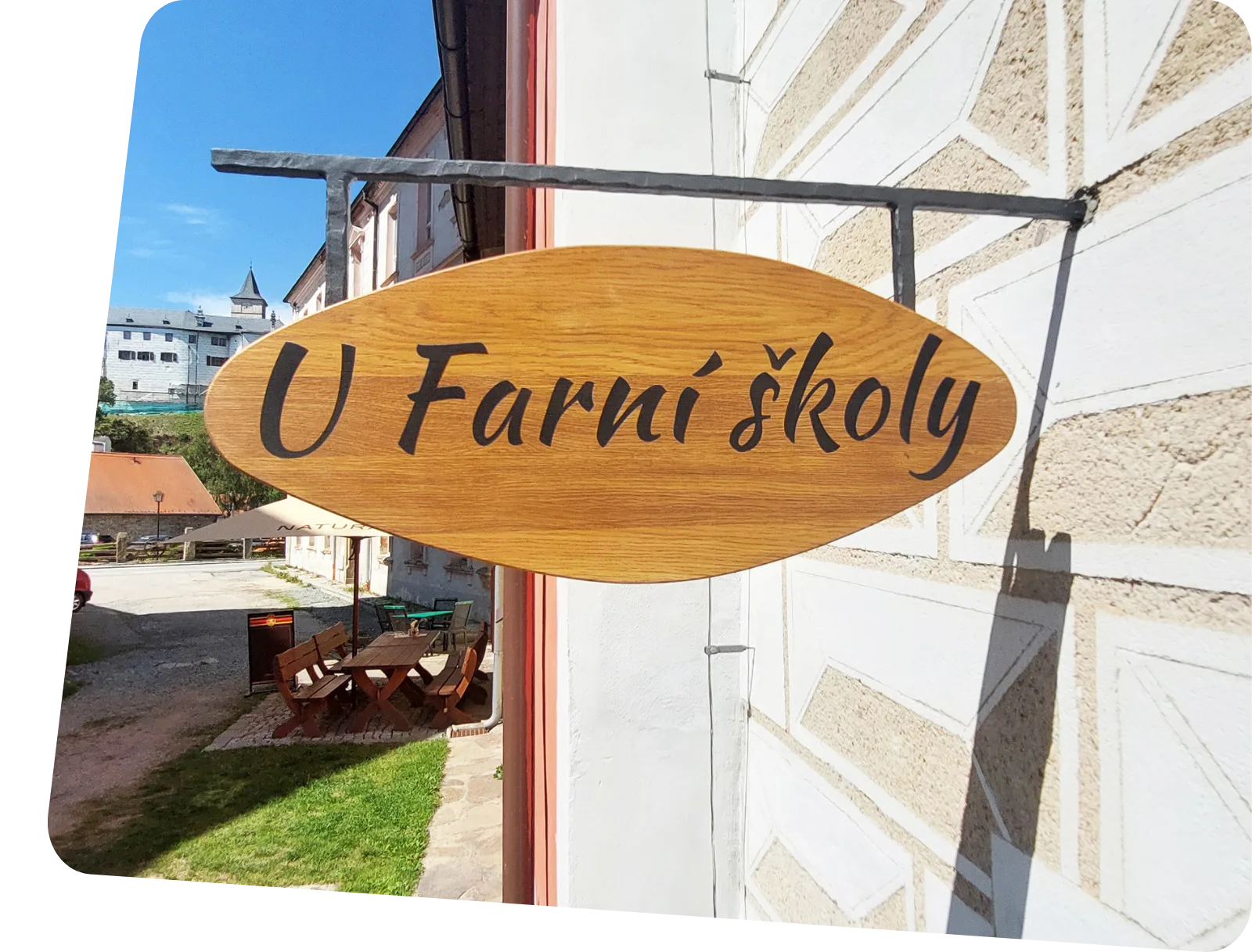 Reklamní výstrč umístěná na fasádě budovy s označením provozovny